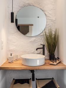 La salle de bains est pourvue d'un lavabo blanc et d'un miroir. dans l'établissement Magma Milos Studios II, à Adamas