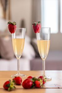 two glasses of champagne and strawberries on a table at Magma Milos Studios II in Adamas
