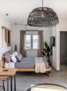 a bedroom with a large bed and a table at Magma Milos Studios II in Adamas