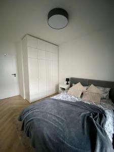 a bedroom with a large bed and a white wall at Casa Baltico Letnica in Gdańsk