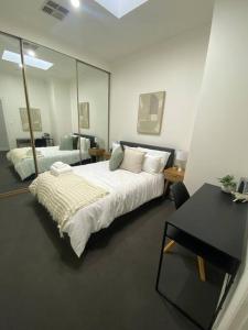 sypialnia z łóżkiem, stołem i lustrem w obiekcie Location location: Melbourne street views w mieście Adelaide