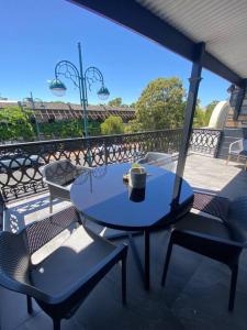 d'une table bleue et de deux chaises sur un balcon. dans l'établissement Location location: Melbourne street views, à Adélaïde