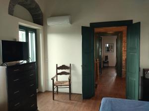 - une chambre avec une télévision, une chaise et une commode dans l'établissement Pure Nature House, à Andros