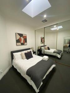 - une chambre avec un grand lit et un miroir dans l'établissement Location location: Melbourne street views, à Adélaïde