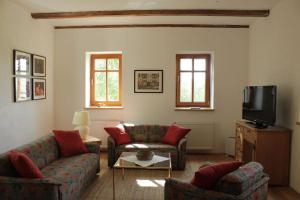 a living room with two couches and a tv at Kellerstöckl - Am Vierkanthof 