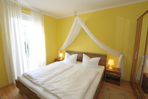 a bedroom with a white bed with a canopy at Villa Lena - Ferienwohnung 03 mit Balkon in Ostseebad Sellin
