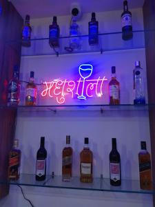 a neon sign in a refrigerator with bottles of alcohol at Satopanth The Auli Resort By Royal Collection Hotels in Joshīmath