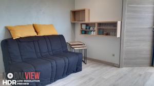- un salon avec un canapé bleu dans l'établissement LES GOELLETTES : vue mer et piscine, à Saint-Cyprien