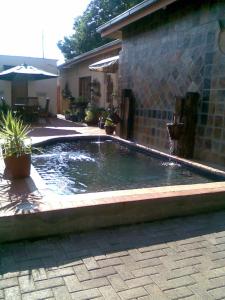 a pool of water in a yard next to a building at Khokha Moya Guesthouse in Ermelo