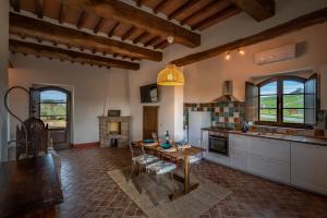 a large kitchen with a table and a dining room at Podere Fossaccio Casa Fiordaliso in Asciano