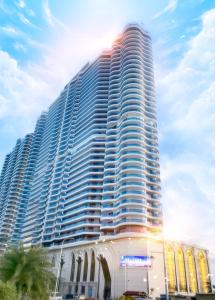 un gran edificio alto con una palmera delante en Howard Johnson Plaza by Wyndham Blue Bay Sihanoukville, en Sihanoukville