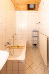a white bathroom with a tub and a sink at Landhaus Rainer in Mallnitz