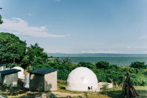 Lubo的住宿－Cozy Dome Glamping w/ Private Hot Spring (2pax)，一组以海洋为背景的帐篷