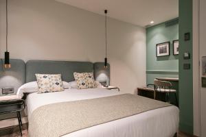 ein Schlafzimmer mit einem großen Bett mit grünen Wänden in der Unterkunft Hotel Via Augusta in Barcelona