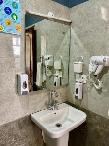 y baño con lavabo y espejo. en Alt Life - Dharamkot (Mcleodganj), en McLeod Ganj
