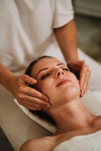 una mujer recibiendo un masaje de un terapeuta en Hotel Der Heinrichshof, en Lagundo