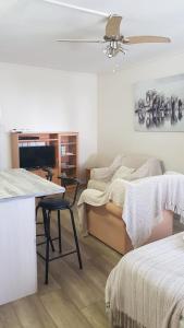 a living room with a bed and a table and a couch at Albatross Beach Guest House in Jeffreys Bay