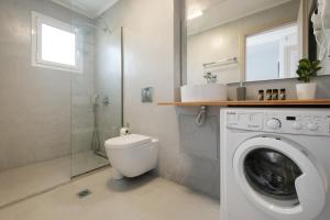 a bathroom with a washing machine and a shower at spiti lithero in Arillas