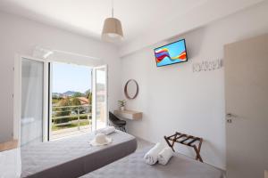 a white room with two beds and a window at spiti lithero in Arillas