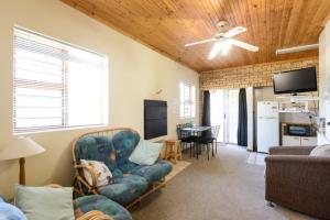 a living room with a couch and a ceiling fan at Albatross Beach Guest House in Jeffreys Bay