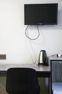 Pokój z biurkiem i telewizorem na ścianie w obiekcie Hotel Tahar w mieście Ałma-Ata