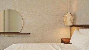 1 dormitorio con cama blanca y espejo en Areos Polis Boutique Hotel, en Areopoli