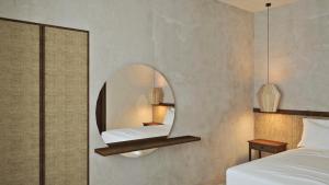 1 dormitorio con espejo en la pared en Areos Polis Boutique Hotel, en Areopoli