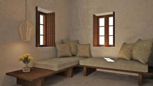 a living room with a couch and two windows at Areos Polis Boutique Hotel in Areopoli