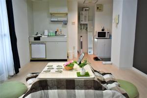a living room with a table and a kitchen at Carid Shiraishi In front of the station / Vacation STAY 4651 in Sapporo