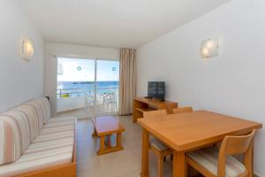 a living room with a couch and a table and a dining room at Apartamentos Mar y Playa in Ibiza Town