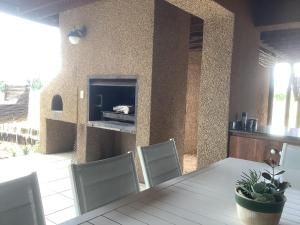 a dining room with a table and chairs and a fireplace at Luna rossa 19 Zebula golf course and spa resort in Mabula