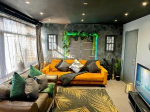 a living room with an orange couch in a room at The Cave House Canterbury with Hot Tub in Kent