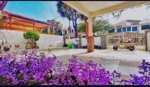 a house with a garden with purple flowers at Batuferringhi children waterslid paradise 3mins to the beach in Batu Ferringhi