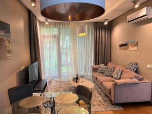 尤爾馬拉的住宿－Jurmala Lux Apartments - Seaside，客厅配有沙发和桌子