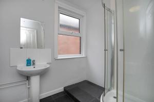 a white bathroom with a sink and a shower at Hömli*Close2City*LargeGroup*Wi-Fi* in Leicester