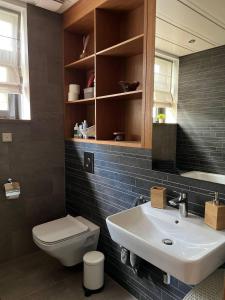 La salle de bains est pourvue d'un lavabo blanc et de toilettes. dans l'établissement Jurmala Lux Apartments - Seaside, à Jurmala