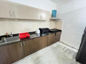 a kitchen with a sink and a microwave at BedChambers Serviced Apartment, Jubilee Hills in Hyderabad