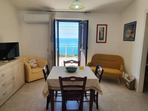 Sala de estar con mesa de comedor y vistas al océano en Appartamento - Plemmirio en Siracusa