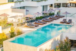 an overhead view of a swimming pool with chairs and umbrellas at Downtown Park in Paphos City