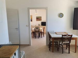 Appartamento - Plemmirio في سيراكوزا: مطبخ وغرفة طعام مع طاولة وكراسي