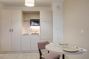 a white dining room with a white table and chairs at Twenty Business Flats Lille - Bayard in Lille