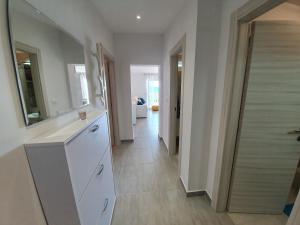 a kitchen with white cabinets and a hallway at Comfortable family apt Iris 20m from beach in Mandre in Mandre