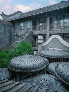 a building with two tables and a bench on a balcony at Diaoyutai Boutique Hotel Chengdu in Chengdu
