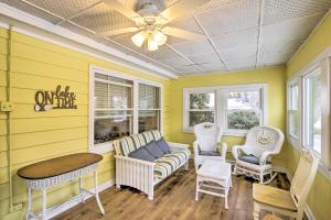 une chambre jaune avec un canapé et des chaises dans l'établissement Green Lake Vacation Home with Screened Porch!, à Green Lake