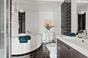 a bathroom with a tub and a toilet and a sink at Villa Ulvatorp nära Varberg och Ullared in Veddige