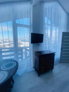 PilipetsにあるDACHA на Магуріのベッドルーム1室(テレビ付)、窓の前にドレッサーが備わります。