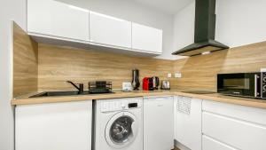 a kitchen with a washing machine and a microwave at HOMEY FRIENDLY - Proche Gare - Terrasse privée - Wifi in La Roche-sur-Foron