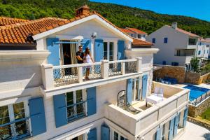a bride and groom standing on the balcony of a house at Rooms Salvia in Cres