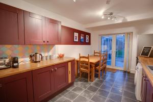 a kitchen with wooden cabinets and a table with a dining room at ST MARGARETS - Spacious Home, High Speed Wi-Fi, Free Parking, Garden in Swindon