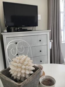 a white dresser with a television on top of it at Seaforth Suite in Simonʼs Town